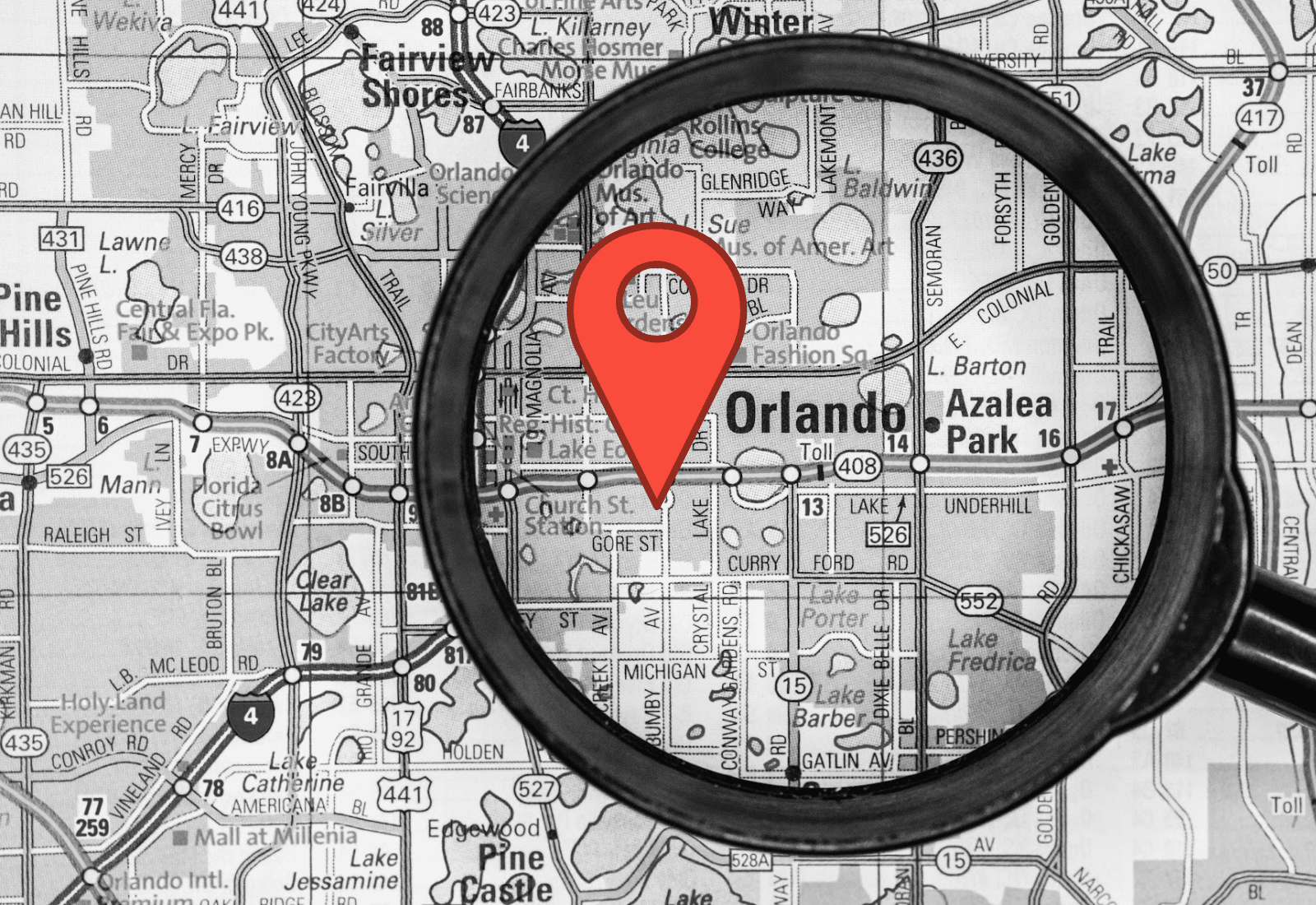 magnifying glass laid on map of Orlando with illustrated map pin